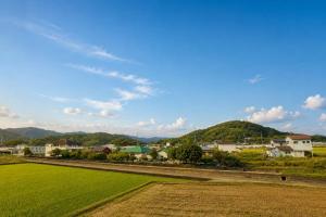 a view of a town with a green field at ゲストハウスガーデンズmihama in Wada +8 photos