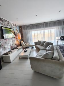 a living room with a couch and a tv at Beach Hub in São Martinho do Porto