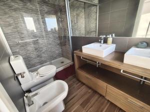 a bathroom with a toilet and a sink and a shower at Beach Hub in São Martinho do Porto