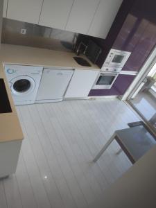 a kitchen with a washing machine in a room at Beach Hub in São Martinho do Porto +5 photos