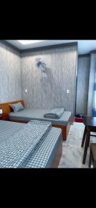 a room with three beds and a fan at Khách sạn Hoàng Đại in Buôn Kuop