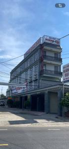 a large white building with a balcony on a street at Khách sạn Hoàng Đại in Buôn Kuop