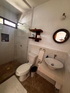a bathroom with a toilet and a sink at Tropical Garden Suites steps from the Lagoon in Bacalar