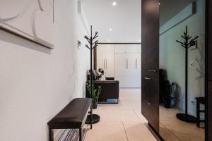 a room with a hallway with a chair and a mirror at CITY-APARTMENT's in Winterthur