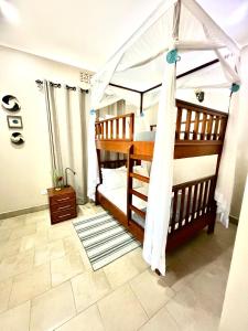 a bedroom with two bunk beds with a canopy at The Angelique Oasis in Arusha