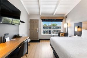 a hotel room with a bed and a desk and a window at Thunderbird Lodge in Redding