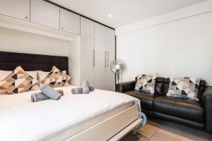 a bedroom with a bed and a leather couch at CITY-APARTMENT's in Winterthur +20 photos