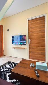 a living room with a door and a tv at Villa Alibaba E5 in Tlekung +3 photos