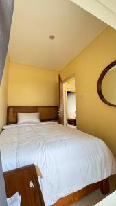 a bedroom with a large white bed and a mirror at Villa Alibaba E5 in Tlekung