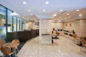 a lobby with tables and chairs and a kitchen at Villa Fontaine Tokyo Nihombashi Hakozaki in Tokyo