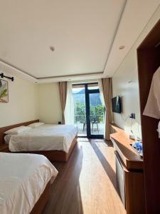 a hotel room with two beds and a window at Wind Village in Hà Lời