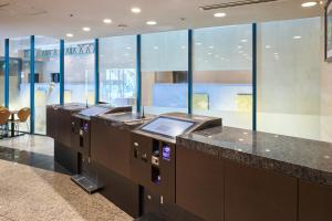 a lobby with a row of counters and windows at Villa Fontaine Tokyo Nihombashi Hakozaki in Tokyo +13 photos