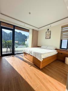 a bedroom with a large bed and a large window at Wind Village in Hà Lời