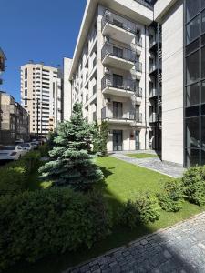 an apartment building with a tree in front of it at Cozy corner Komitas in Yerevan