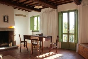 Zimmer mit einem Tisch, Stühlen und einem Kamin in der Unterkunft L'Ariete in Montone
