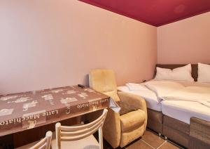 ザールバッハ・ヒンターグレムにあるAppartement Snowflakeのベッド2台、テーブル、椅子が備わる客室です。