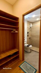a bathroom with a toilet and a glass door at Beehive El Nido in El Nido +34 photos
