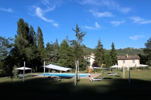 einen Pool in einem Hof mit einem Haus und Bäumen in der Unterkunft L'Ariete in Montone