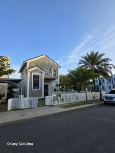 a white house with a white fence and palm trees at Villa Malibu Phan Thiet, Free Parking in Phan Thiet +3 photos