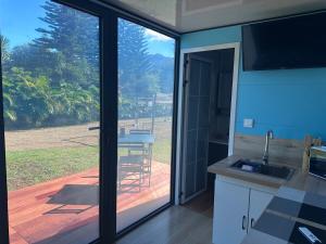a kitchen with a sliding glass door to a deck at L'Horizon de Tontout'ailes in La Tontouta