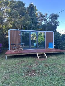 a small cabin with a table and chairs on the grass at L'Horizon de Tontout'ailes in La Tontouta