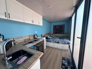 a kitchen with a sink and a bed in a room at L'Horizon de Tontout'ailes in La Tontouta
