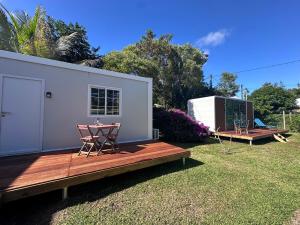 a tiny house with a table and chairs in a yard at L'Horizon de Tontout'ailes in La Tontouta