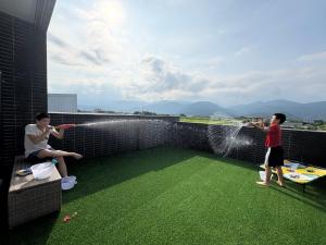 a couple of people playing with water on a roof at 八樂宿 包棟民宿 in Sanxing