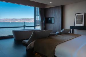 a bedroom with a large bed and a bath tub and a window at Anye Seaview Hotel Dali in Dali