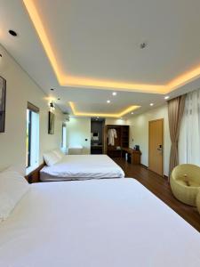 a hotel room with two beds and a chair at Baram Villas Phong Nha in Hà Lời