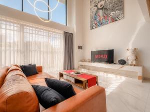 a living room with a couch and a tv at Villa Exquisite Central Seminyak by Nagisa Bali in Seminyak