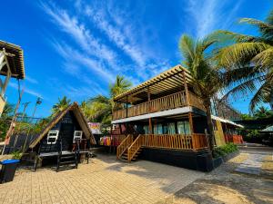 a house on the beach with palm trees at Upgrade Beach Resort Infanta Quezon in Infanta
