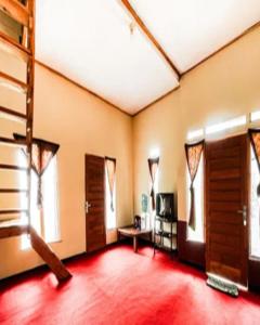 a living room with wooden doors and a red floor at Cozzy Villa RB in Citere