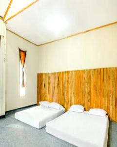 two beds in a room with a wooden wall at Cozzy Villa RB in Citere