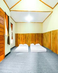 two beds in a room with wooden walls at Cozzy Villa RB in Citere +13 photos