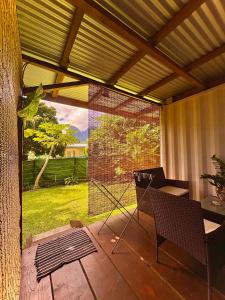 a screened in porch with a table and a chair at Fare Aimeho in Vaianae +12 photos