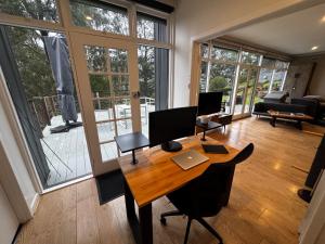 an office with a wooden table with a computer on it at Sunset View House - Rustic Outdoor Bathhouse, Walk to Town in Warburton