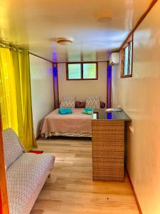 a small room with a bed and a table in it at Fare Aimeho in Vaianae