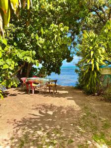 a group of tables sitting on the beach near the water at Fare Aimeho in Vaianae