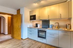 a kitchen with stainless steel appliances and wooden floors at Nanas-Auszeit in Rothenbuch