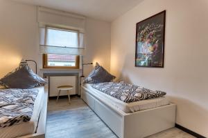 a bedroom with two beds and a picture on the wall at Nanas-Auszeit in Rothenbuch