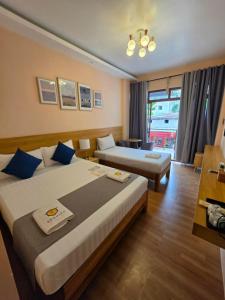 a hotel room with two beds and a window at Beehive El Nido in El Nido