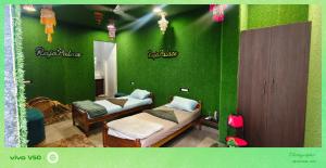 a room with two beds and a green wall at rajapalace in Zahirābād