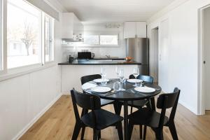 a kitchen and dining room with a black table and chairs at Cedar Lodge in Braidwood