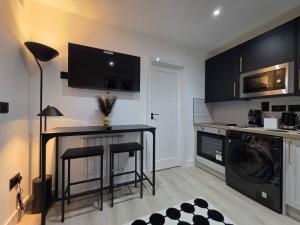 a kitchen with a black table and a washer at Luaz - View Lodge in Dublin