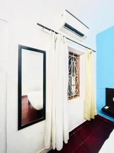 a room with a mirror and white curtains at Hotel White Sand Bache Stay in Aguada