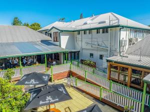 eine Außenterrasse mit Sonnenschirmen vor einem Gebäude in der Unterkunft Maleny Hotel in Maleny