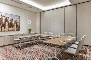 a conference room with a long table and chairs at Adina Chermside Brisbane in Brisbane