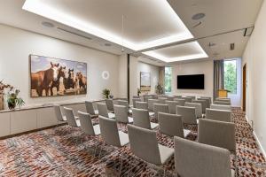 a conference room with chairs and a flat screen tv at Adina Chermside Brisbane in Brisbane