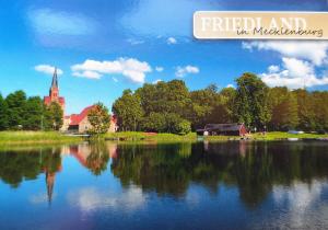 a view of a lake with a church in the background at Auszeit in Friedland +22 photos